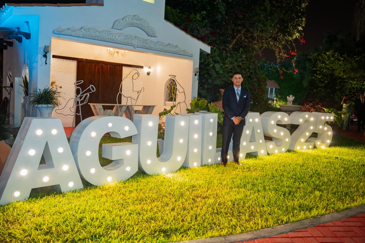 Invitado posando junto a las letras iluminadas Águilas 25 de noche