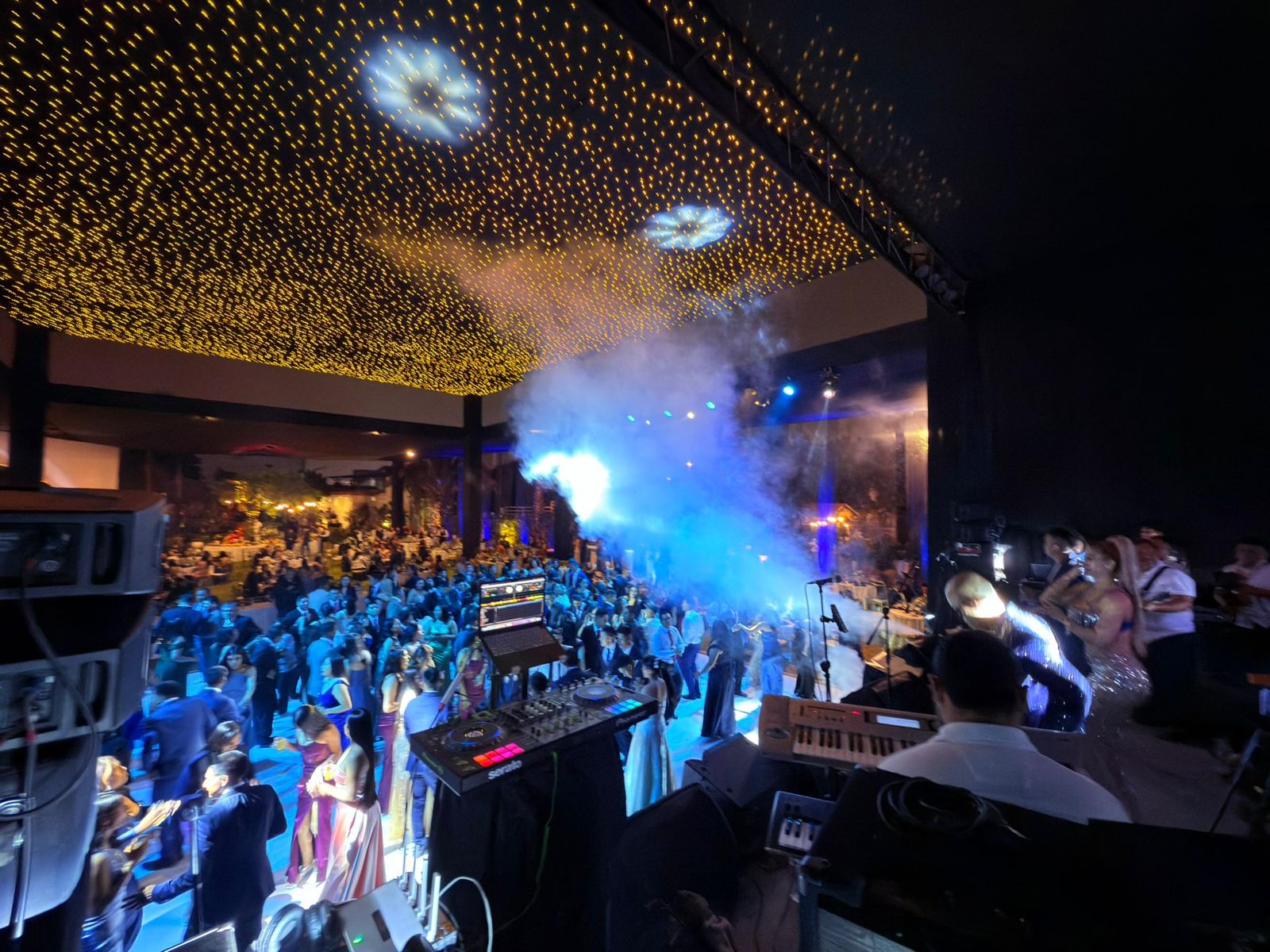 Pista llena con humo y luces durante la fiesta