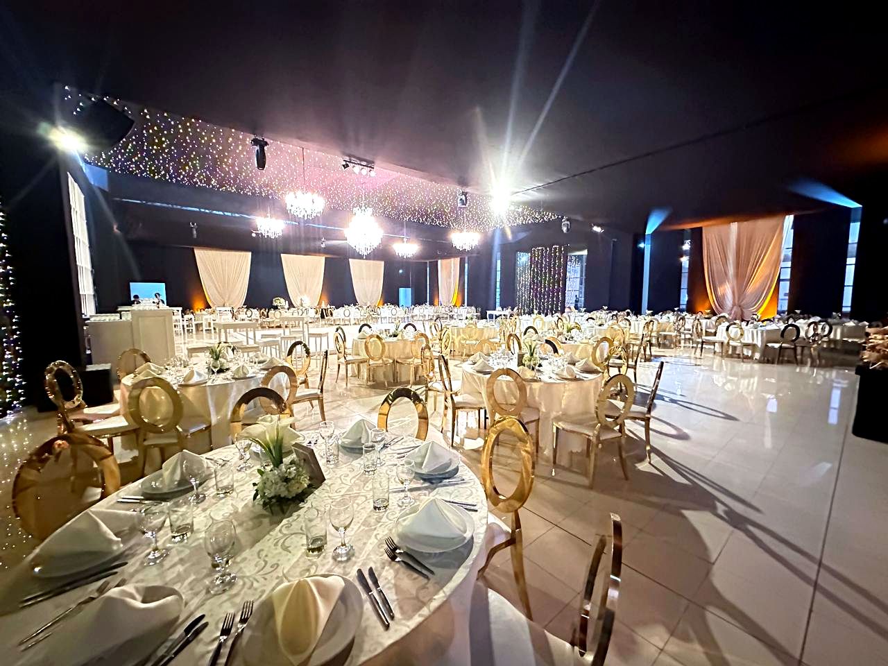 Salón de boda con mesas doradas y candelabros
