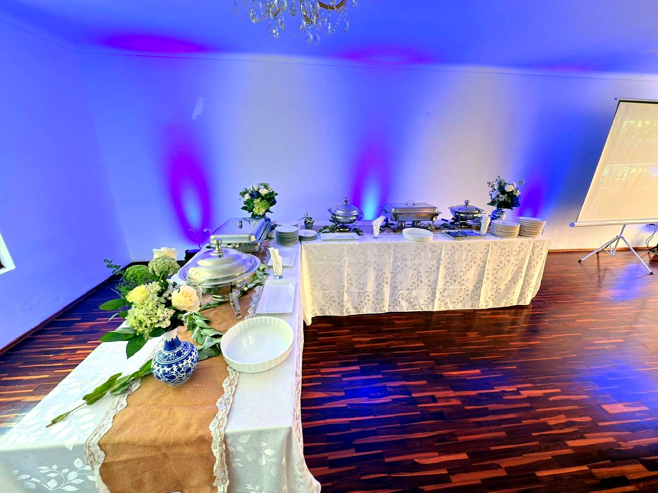 Estación de buffet en forma de L con mantelería blanca