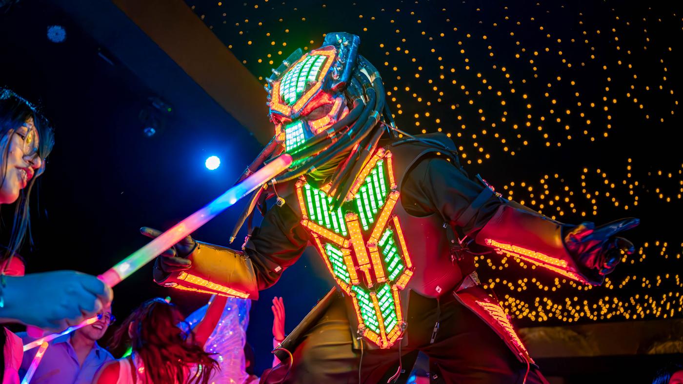 Personaje con traje LED interactuando con invitados