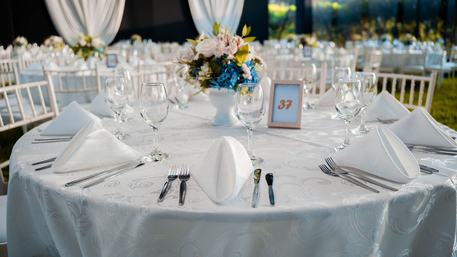 Mesa de gala montada con mantelería blanca y centro floral