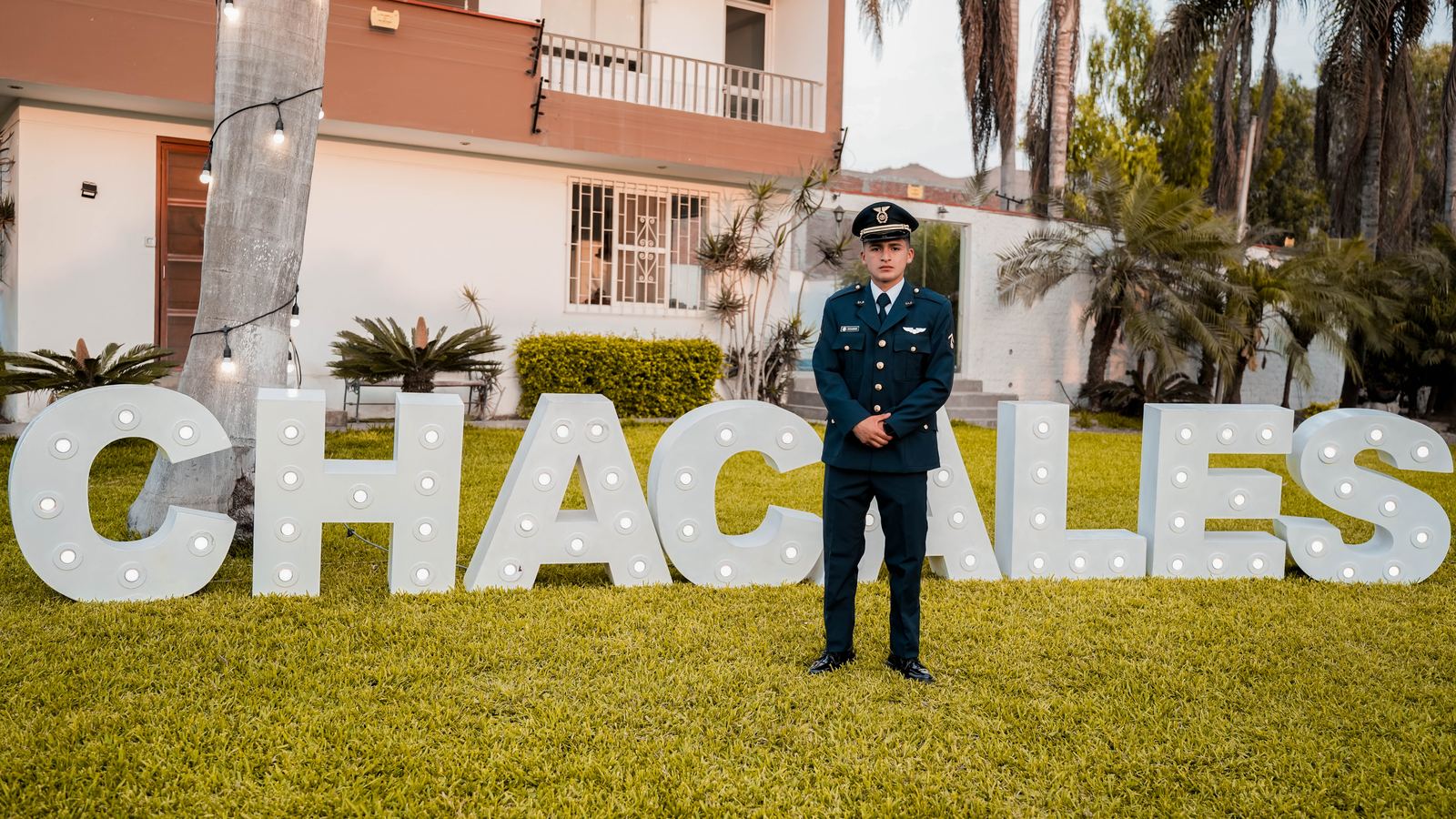 Cadete de la FAP junto a las letras luminosas del evento