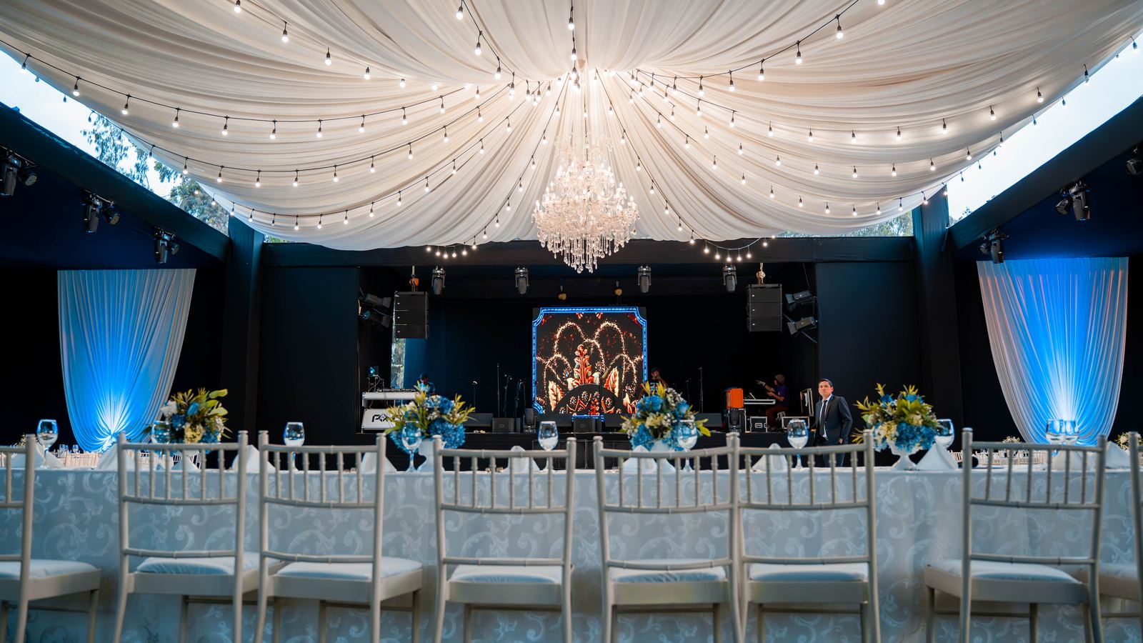 Carpa principal con candelabro de cristal y escenario montado