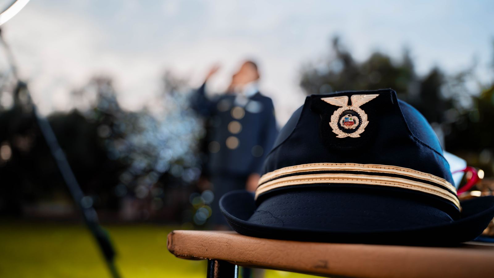 Detalle de la gorra del uniforme institucional sobre una baranda