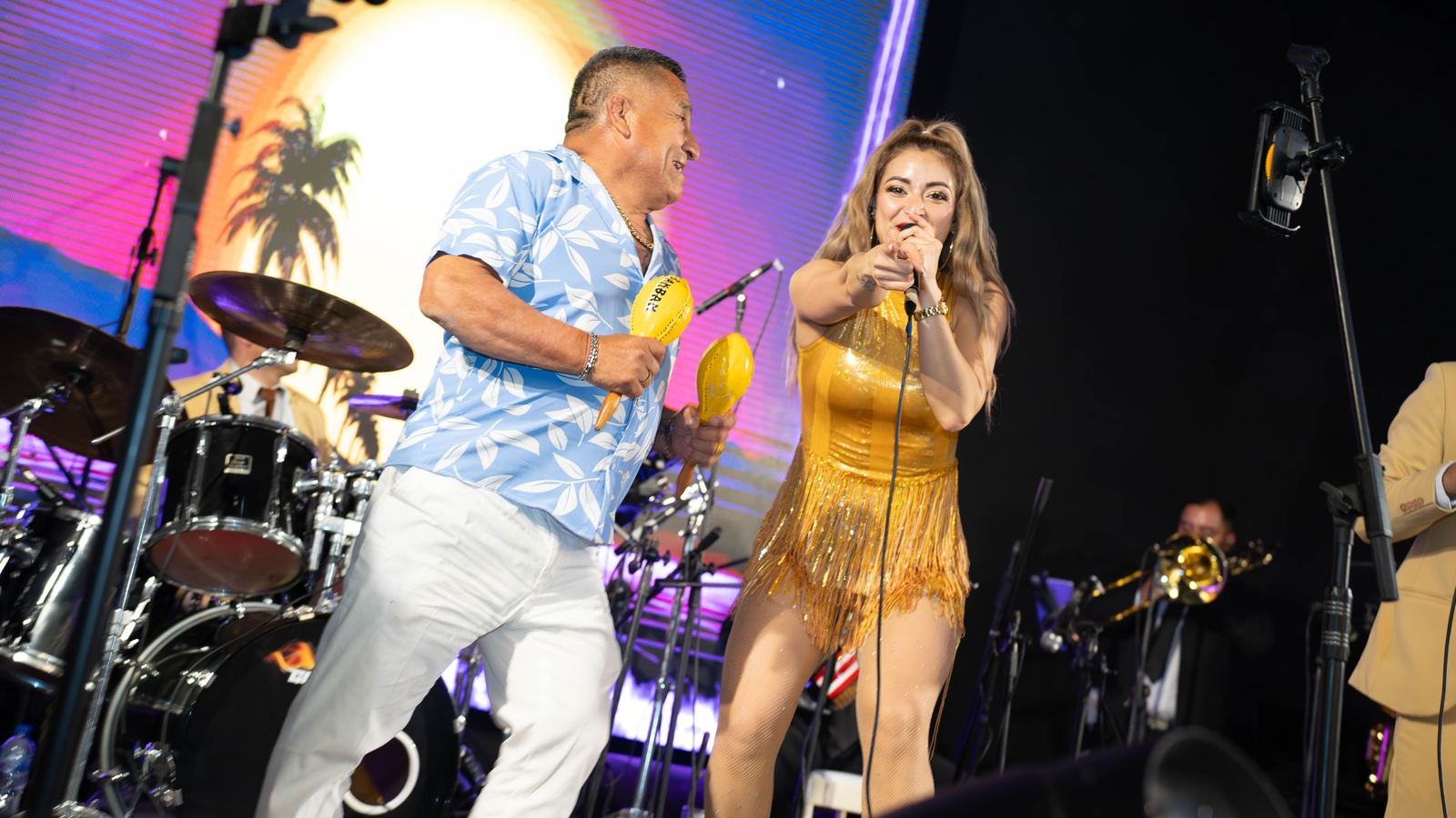 Dúo de cantantes animando la fiesta con maracas